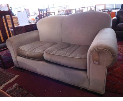 A two seater club sofa with green velour upholstery raised on block feet