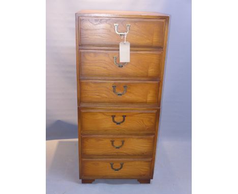 A campaign style dark pedestal chest of six drawers raised on carved bracket feet, H:120cm W:54cm D:41cm