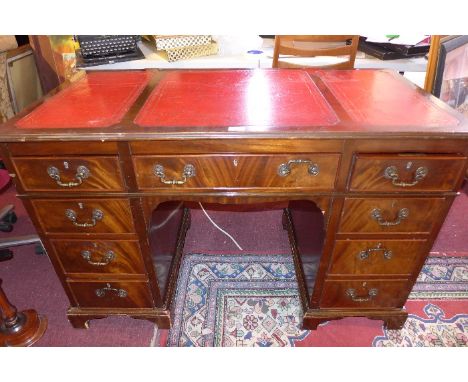 A mahogany kneehole desk with an arrangement drawers on carved bracket feet