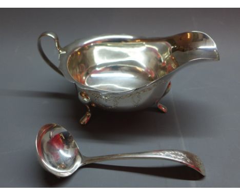 A mid 20th Century silver sauce boat with initials E.V and dated 1960 together with a matching miniature ladle. 