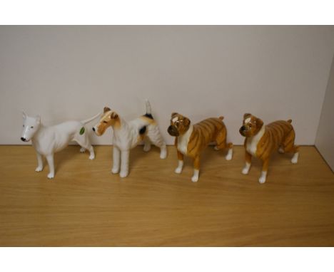 A Group of four Beswick Pottery Dog studies, comprising two Boxers 'Blue Mountain Greta' 1202, in brindle gloss, designed by 