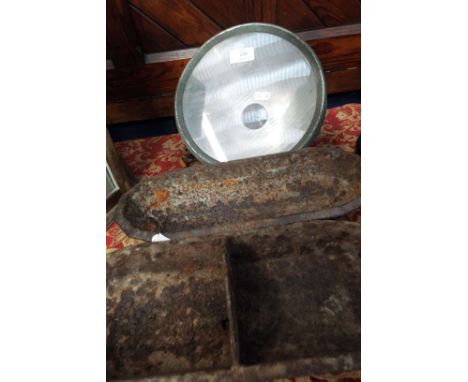 Two small iron feeding troughs and a vintage car headlight