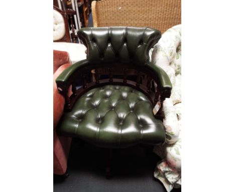 A green leather library captain's chair having button-back and studded upholstery, spindle gallery resting on four splayed su