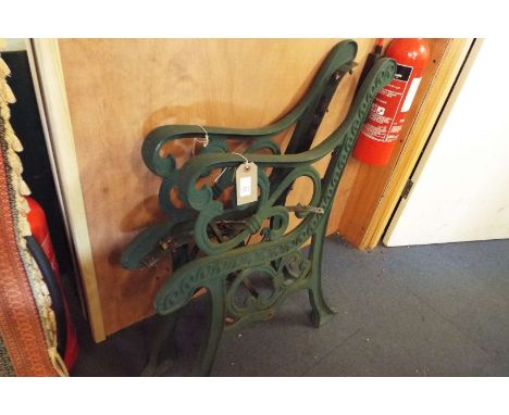A pair of wrought iron garden bench ends