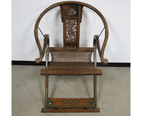 A late 19th Century Chinese Huanghuali horseshoe-back folding arm chair, The chair with a rounded crest rail terminating in o