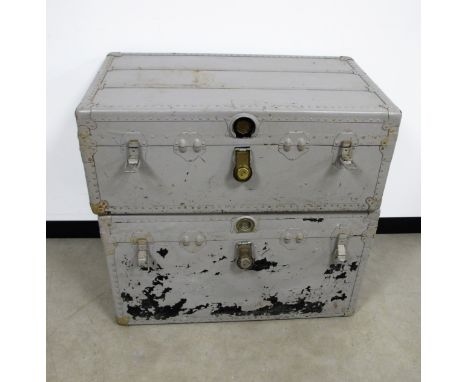 Two vintage metal bound travel trunks, both with lined interiors, lift out trays and leather carrying handles to sides, one A