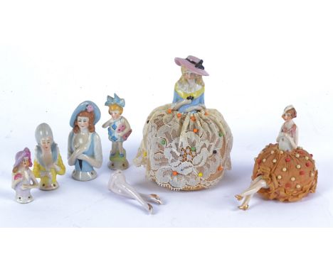 Two early 20th century porcelain pin cushion dolls, together with four other half-dolls and a pair of legs (7) 