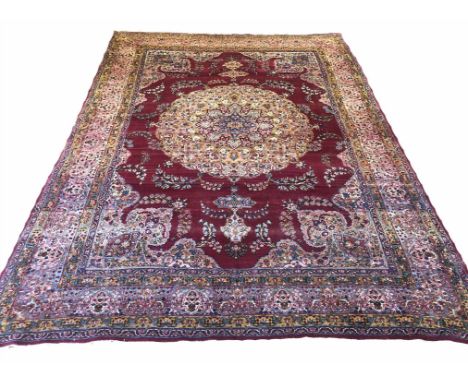 ANTIQUE LAVER KERMAN CARPET, 339cm x 244cm, central medallion on a ruby field of floral vines within complimentary spandrels 