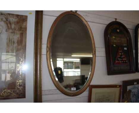 A gilt framed bevel edge oval wall mirror