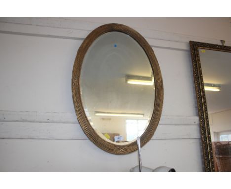 A gilt framed bevel edged oval wall mirror 