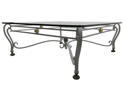Wrought metal and glass top coffee table, square glass top on scrolled supports with brass feet, scrolled stretchers with pin