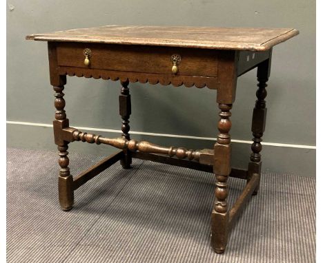 A late 17th/ early 18th century oak side table, the two plank top above a single frieze drawer raised on block and bobbin tur