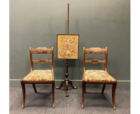 A pair of Regency mahogany dining chairs on sabre front legs together with a George III style mahogany polescreen with needle