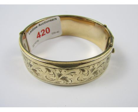 An early 20th Century 1/5 9ct rolled-gold hinged bangle, the face wrigglework and bright cut engraved in a foliate design,