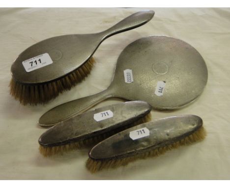 A 4-piece engine turned silver backed brush and mirror set.