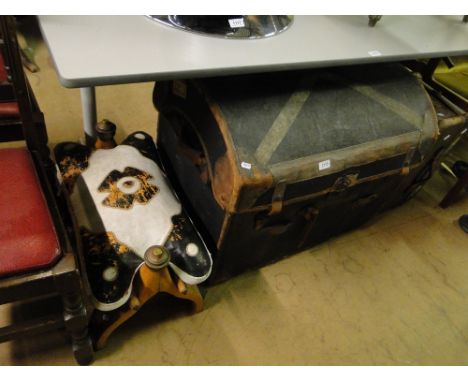 A Vintage domed top trunk, suitcase and a camel saddle.