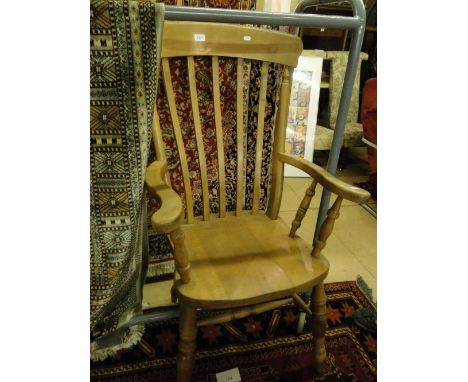 A pine Windsor stick back kitchen elbow chair.