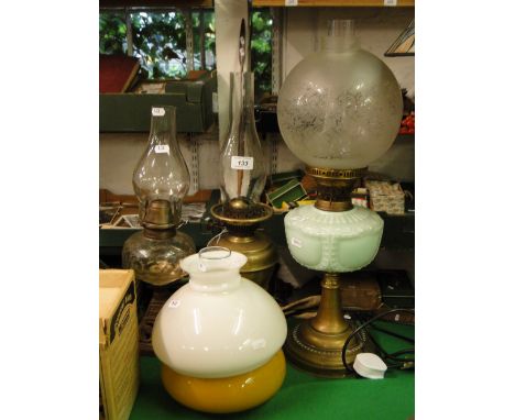 A Victorian oil lamp with milk glass font, shade and chimney and 2 other oil lamps.