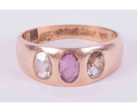 An 18ct rose gold band style ring set with a central oval cut ruby measuring approx. 5.7mm x 3.8mm with one oval cut diamond 