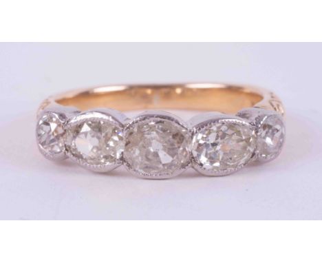 An 18ct yellow &amp; white gold five stone ring with engraved shoulders and set with two old round cut diamonds total weight 