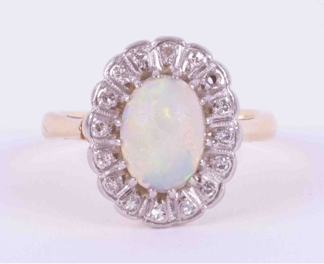 An 18ct yellow gold cluster ring set with a cabochon cut white opal, measuring approx. 9mm x 7mm, surrounded by small old rou