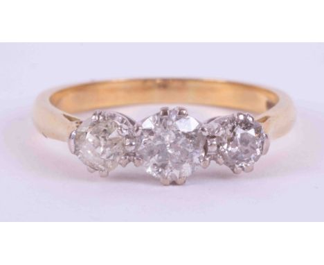 An 18ct yellow &amp; white gold three stone ring set with approx. 1.50 carats total weight of old round cut diamonds, ranging