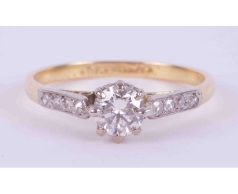 An 18ct yellow gold &amp; platinum ring set with a central round cut diamond approx. 0.35 carats with four small round cut di