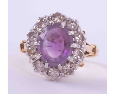 An 18ct yellow &amp; white gold cluster ring set with an oval cut amethyst, approx. 2.18 carats, surrounded by approx. 1.00 c