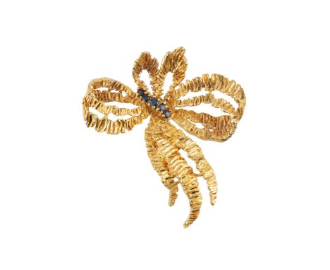 A sapphire set panel brooch, designed as an abstract tied ribbon of textured finish, highlighted with a line of circular mixe