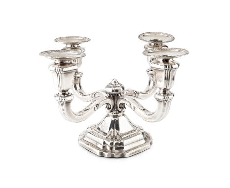 A German silver four branch candlestick, having beaded drip pans, shaped scroll arms and stepped filled base, by Jakob Grimmi