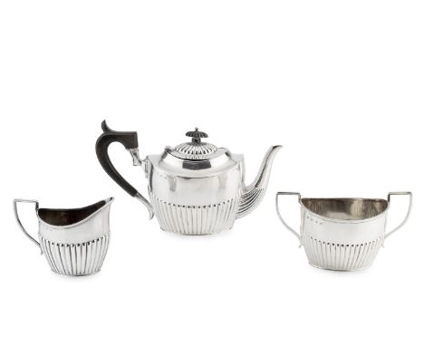 A late Victorian silver three piece tea service, of oval half-lobed design, the teapot with ebonised handle and knop, by Bark