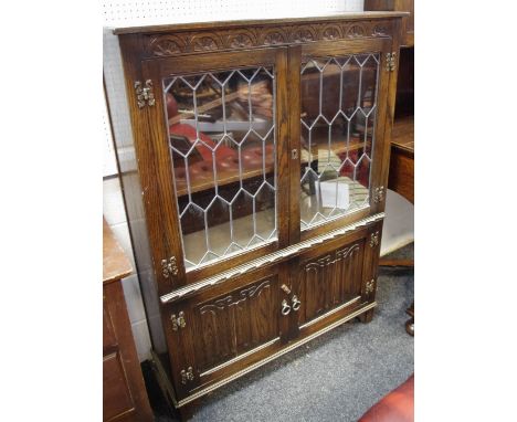 A Jaycee furniture oak side cabinet, rectangular top above a pair of glazed doors enclosing two shelves and a further pair of