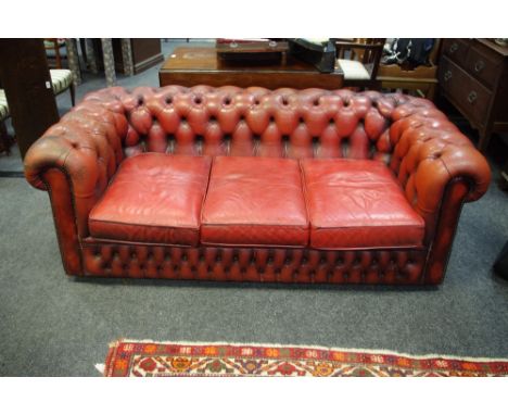 An office reception Sang-de-boeuf three seat Chesterfield sofa.