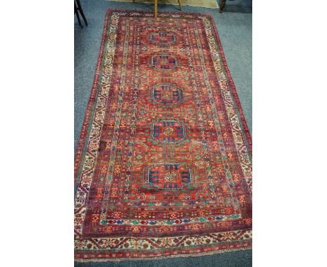 A hand woven Turkman carpet geometric centre panel with banded border. 273cm x 137cm.