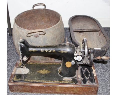 A cast iron feeding trough; a cast iron pan; a Singer sewing machine