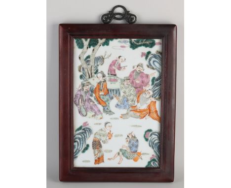 Large Chinese porcelain Family Rose tile with figures in garden/gold decor. In hardwood frame. Dimensions: H 36 x W 24 cm. In