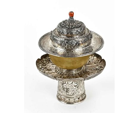 Tibetan jade teacup with lid, on silver base. Jade cup placed on a silver holder with a wide scalloped edge, richly decorated