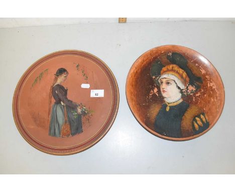 A figural plaque or stand marked Torquay Terracotta Company together with a similarly decorated plate (2)