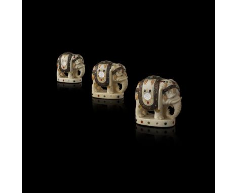 THREE SHIBAYAMA-INLAID MINIATURE ELEPHANTSSIGNED ISSHI, MEIJI PERIOD each carved standing foursquare with trunk lowered, the 