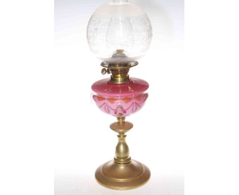 Victorian brass oil lamp with pink decorated glass reservoir and etched and frosted glass shade.