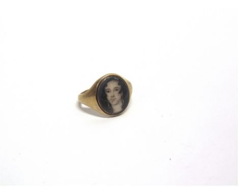 A LATE 19TH CENTURY UNMARKED GOLD SIGNET RING set with a portrait miniature of a girl, under glass, finger size V1/2, 5g gros