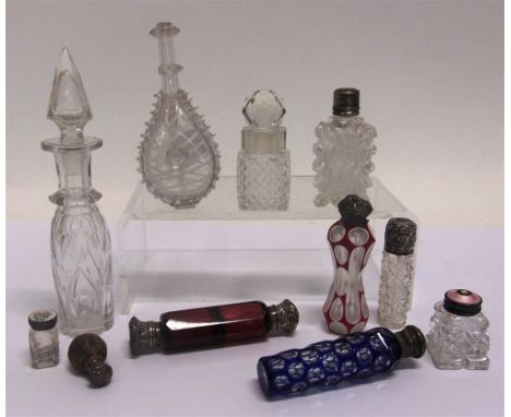 A COLLECTION OF GLASS SCENT BOTTLES  including silver mounted and flash cut examples, a double-ended cranberry glass flask et