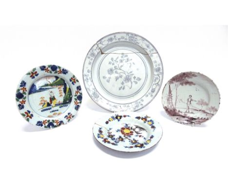 AN 18TH CENTURY DELFT PLATE  manganese decoration of a figure in a landscape, 19cm diameter; another delftware charger, thinl
