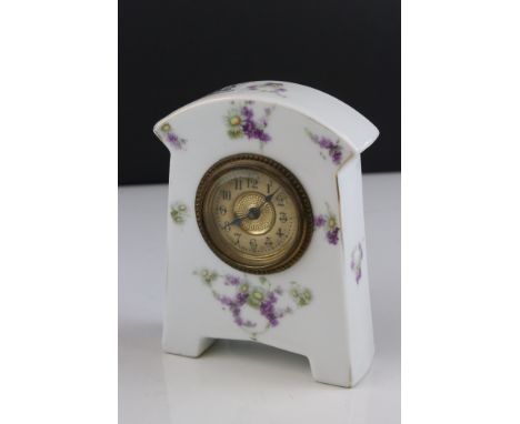 An antique porcelain cased clock with floral decoration. 