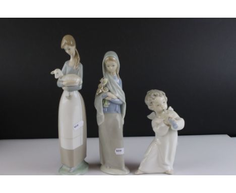 Three Lladro Figures including Girl holding Lilies, Girl holding a Lamb and Angel playing a Musical Instrument, tallest 27cms