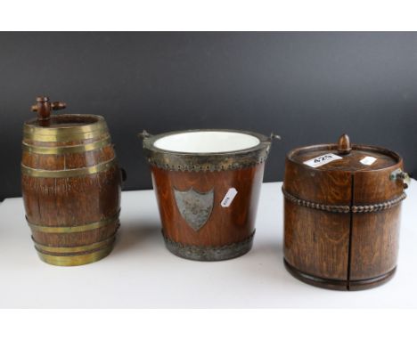 A group of three wooden collectables to include a biscuit barrel, a tea caddy and a brass bound keg. 