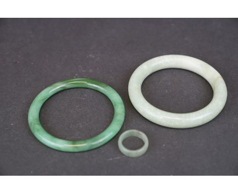 Two oriental carved Jade bangles together with a Jade ring. 