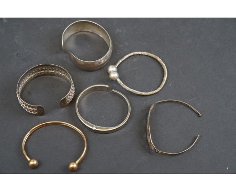 A hallmarked 9ct gold bangle bracelet together with a selection of silver and white metal examples. 
