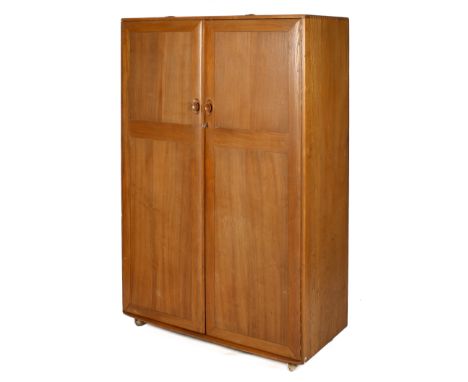 A mid-century Ercol Windsor two door wardrobe. Of solid elm blue label inside door features a flat spacious top above two ful