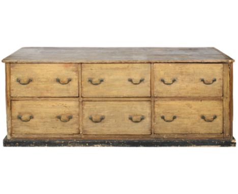 A large early 20th century oak bank of drawers shop counter. Having six deep drawers with brass swing handles raised on a pli